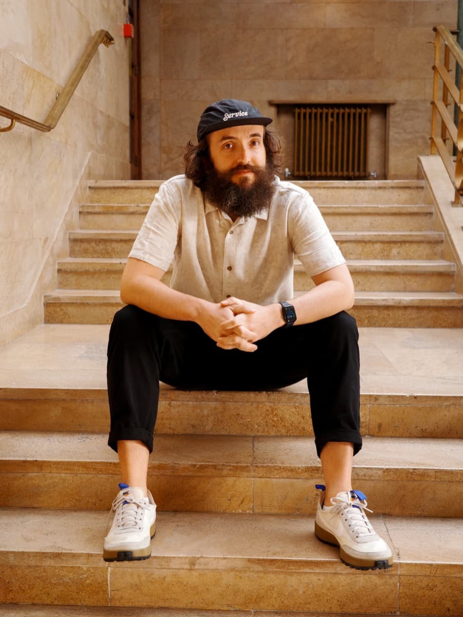Alex Andrews, sitting on stone steps